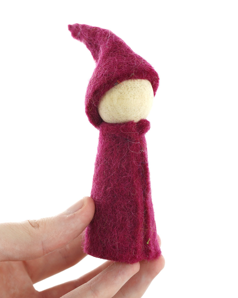 Close up of a hand holding a Papoose felt rainbow gnome toy on a white background