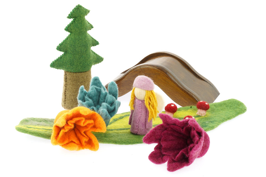 3 Papoose handmade felt daffodil flowers on a green play mat next to a Papoose bright elf