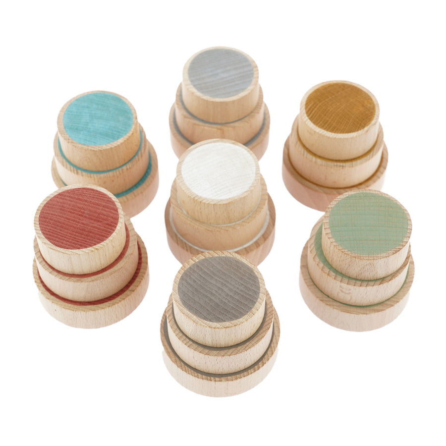 Papoose plastic-free wooden earth coins stacked in piles on a white background