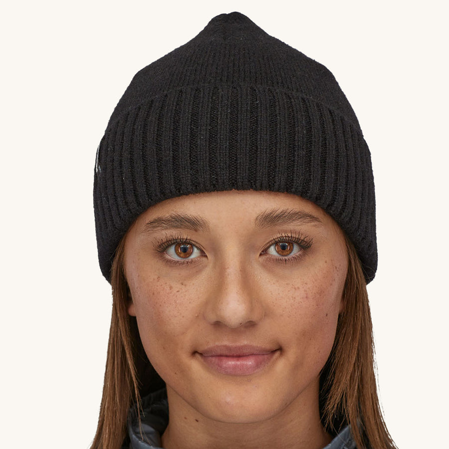 Patagonia Brodeo Beanie Hat - Black. A woman models the front of the hat against a plain background.