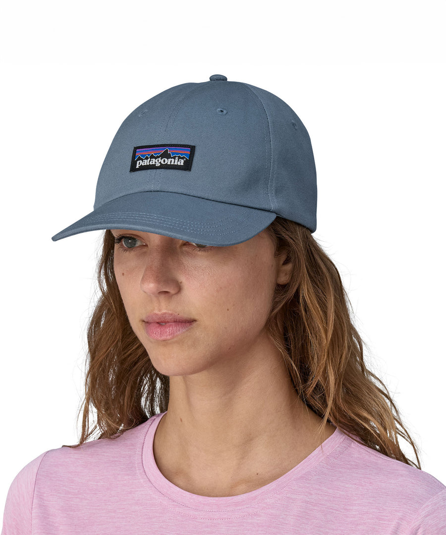 A woman wearing a Patagonia Adult P-6 Label Trad Cap in a mid utility blue colour.