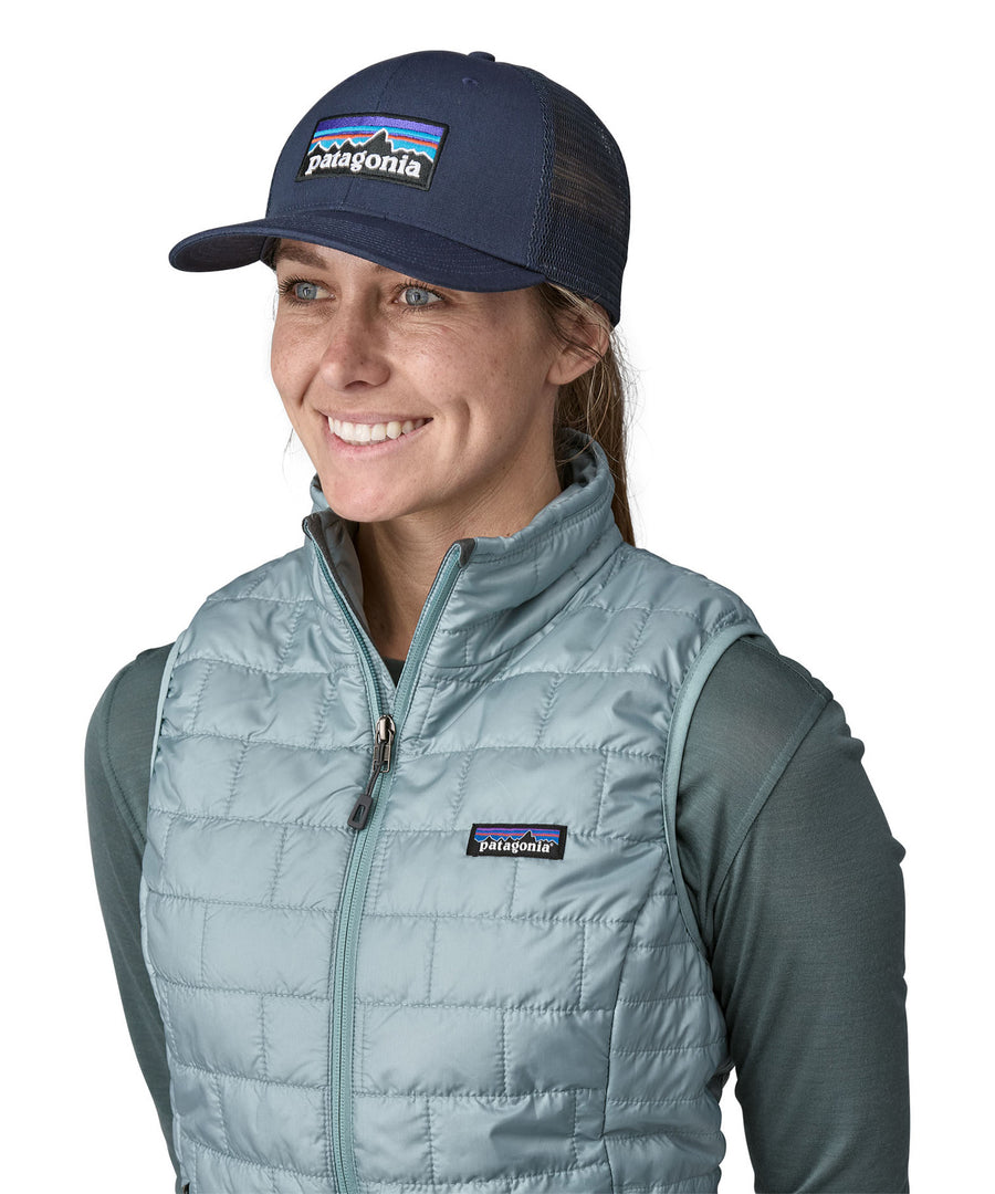 A woman wearing a Patagonia Adult P-6 Logo Trucker Hat in New Navy