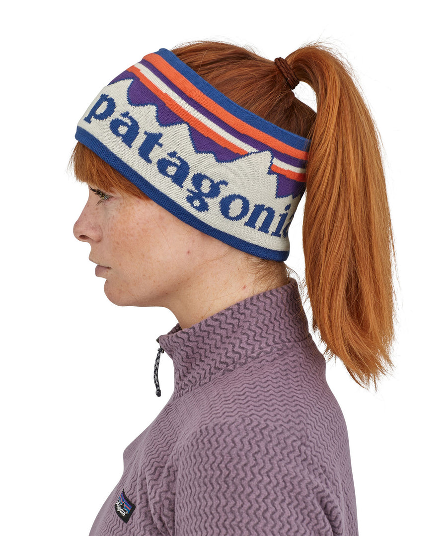 A side profile view of a woman wearing the Patagonia Adult Powder Town Headband Birch White