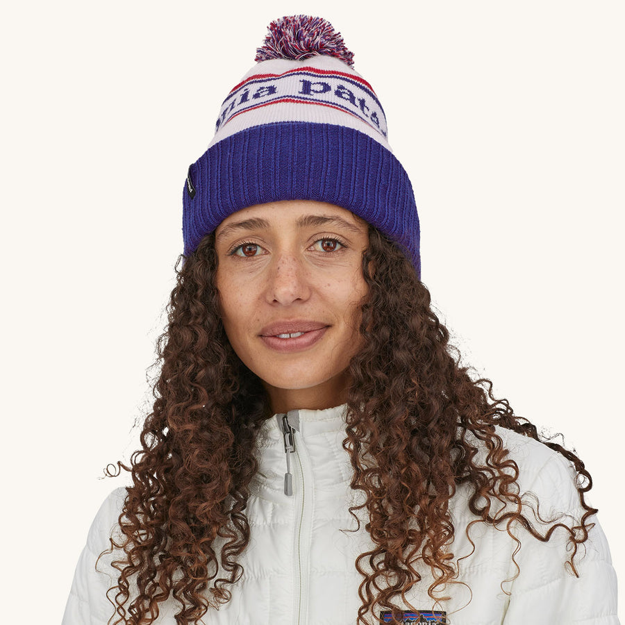 Patagonia Powder Town Beanie Bobble Hat - Park Stripe / Viking Blue. A woman wears the beanie facing forwards against a plain background.