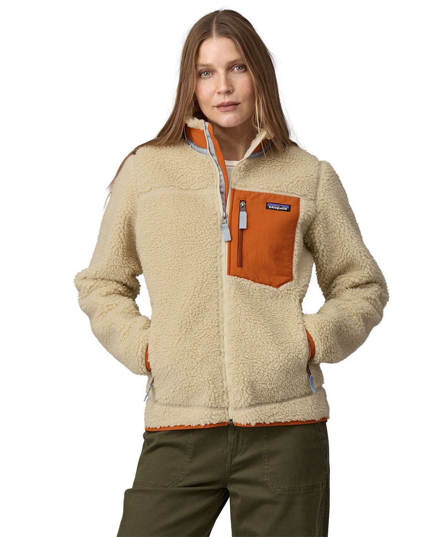 A woman wearing a Patagonia Women's Classic Retro-X Jacket in a Dark Natural colour standing against a plain background.