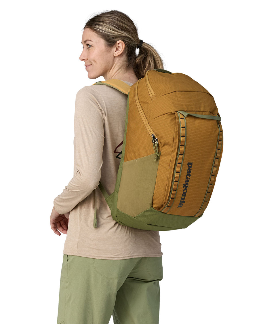 A person wearing the Patagonia Black Hole Recycled Backpack 32L - Pufferfish Gold