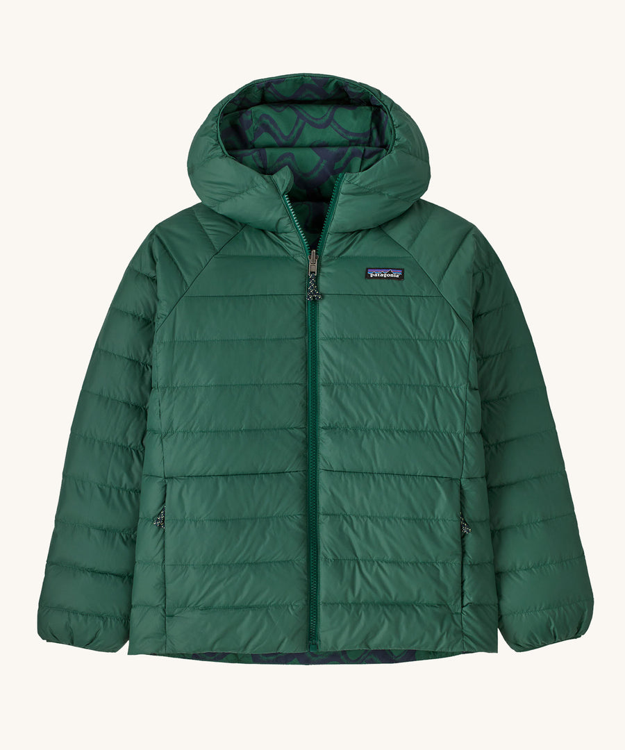 Patagonia Kids Reversible Down Hoody in a Conifer Green colour on a plain background. 