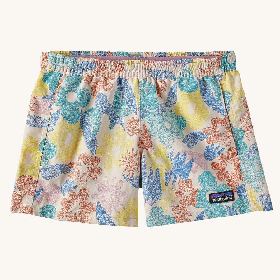 The Patagonia Kids Baggies Shorts in Channeling Spring / Natural are white with a colourful retro spring flowers pattern and have a Patagonia logo tag on the left hem