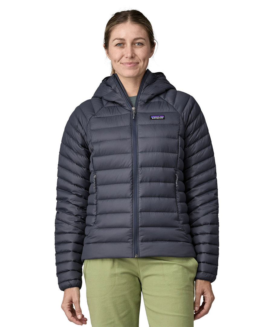 A woman wearing a Patagonia Women's Down Sweater Hoody in a Smolder Blue colour.