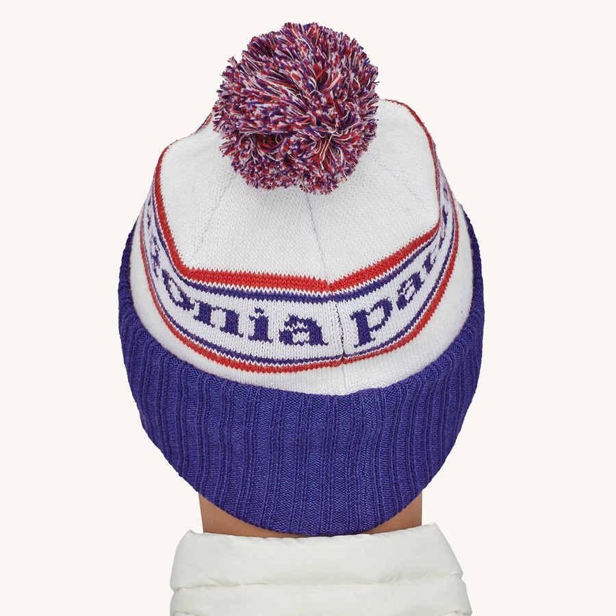 Patagonia Powder Town Beanie Bobble Hat - Park Stripe / Viking Blue. A woman wears the beanie facing away from camera against a plain background.