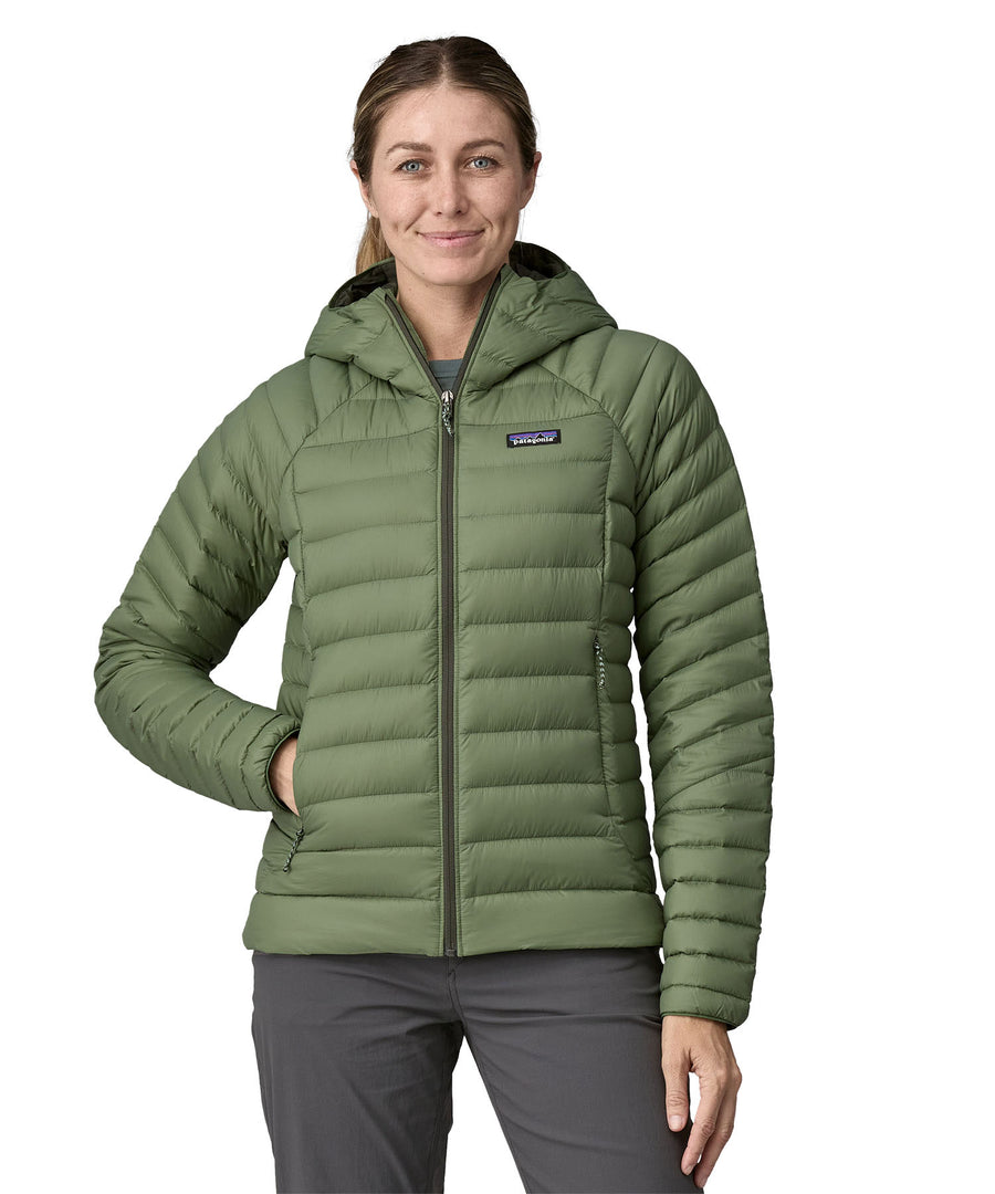 A woman wearing a Patagonia Women's Down Sweater Hoody in terrain green.