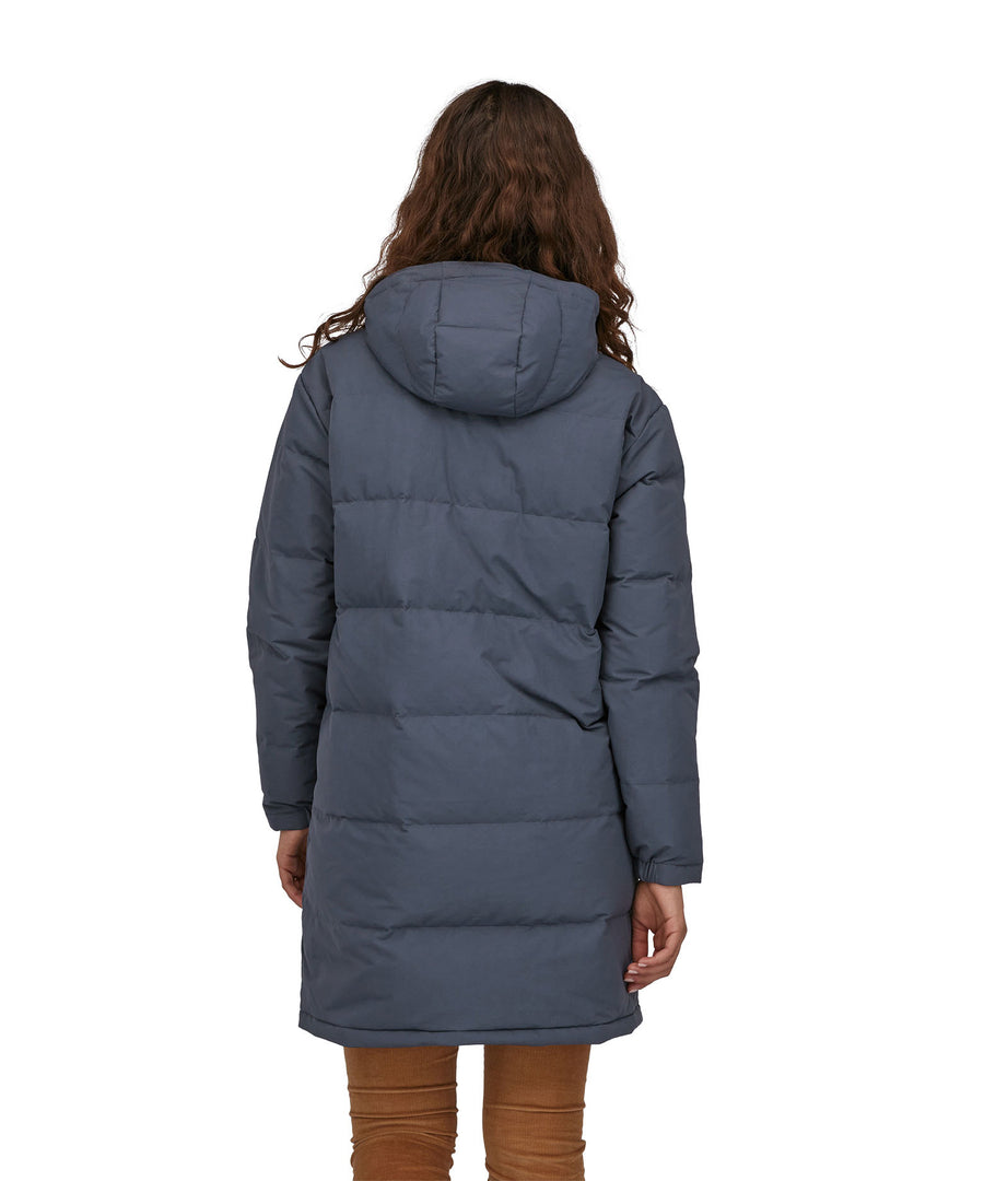 A view of the back of a woman wearing the Patagonia Women's Downdrift Parka in Pine Smolder Blue