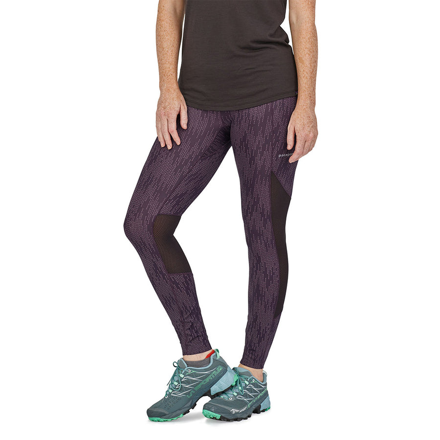 Woman wearing the Patagonia recycled polyester slim fit running tights on a white background