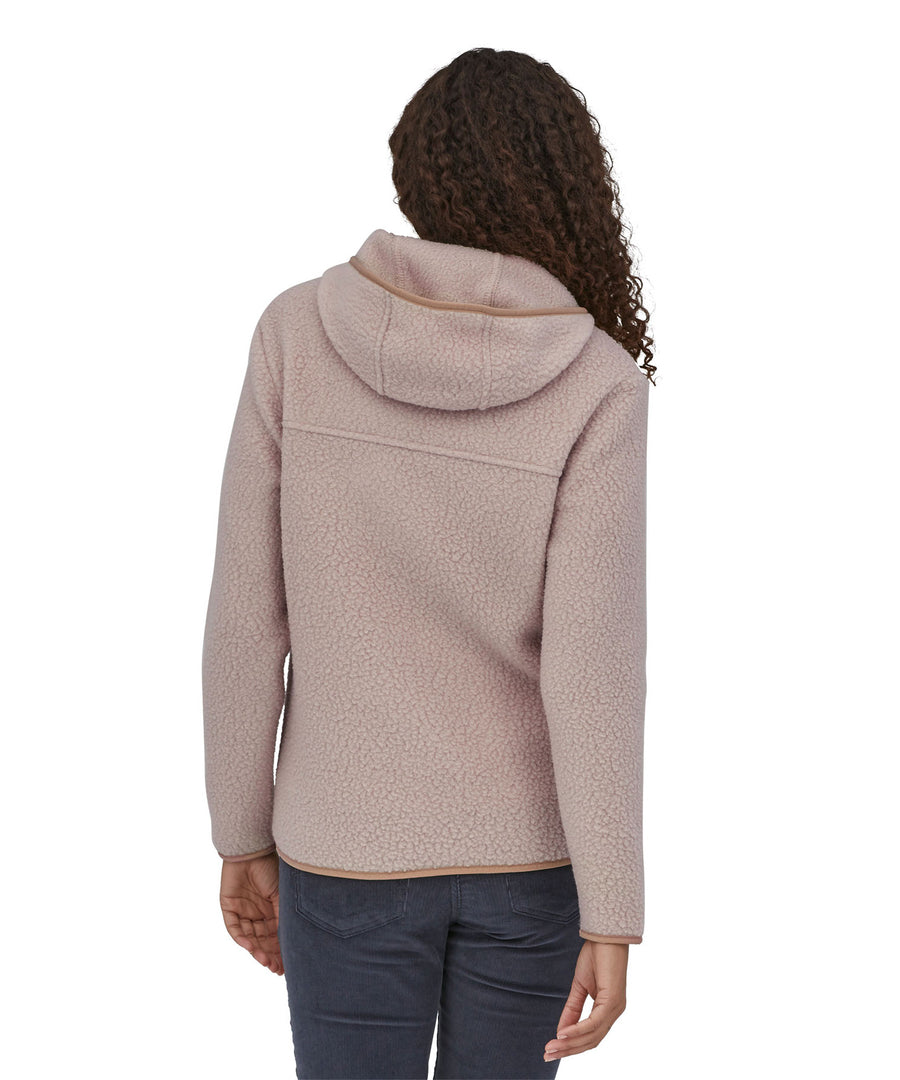 A woman with long curly hair wearing a  Patagonia Women's Retro Pile Hoody Shroom Taupe showing the back of the jacket.