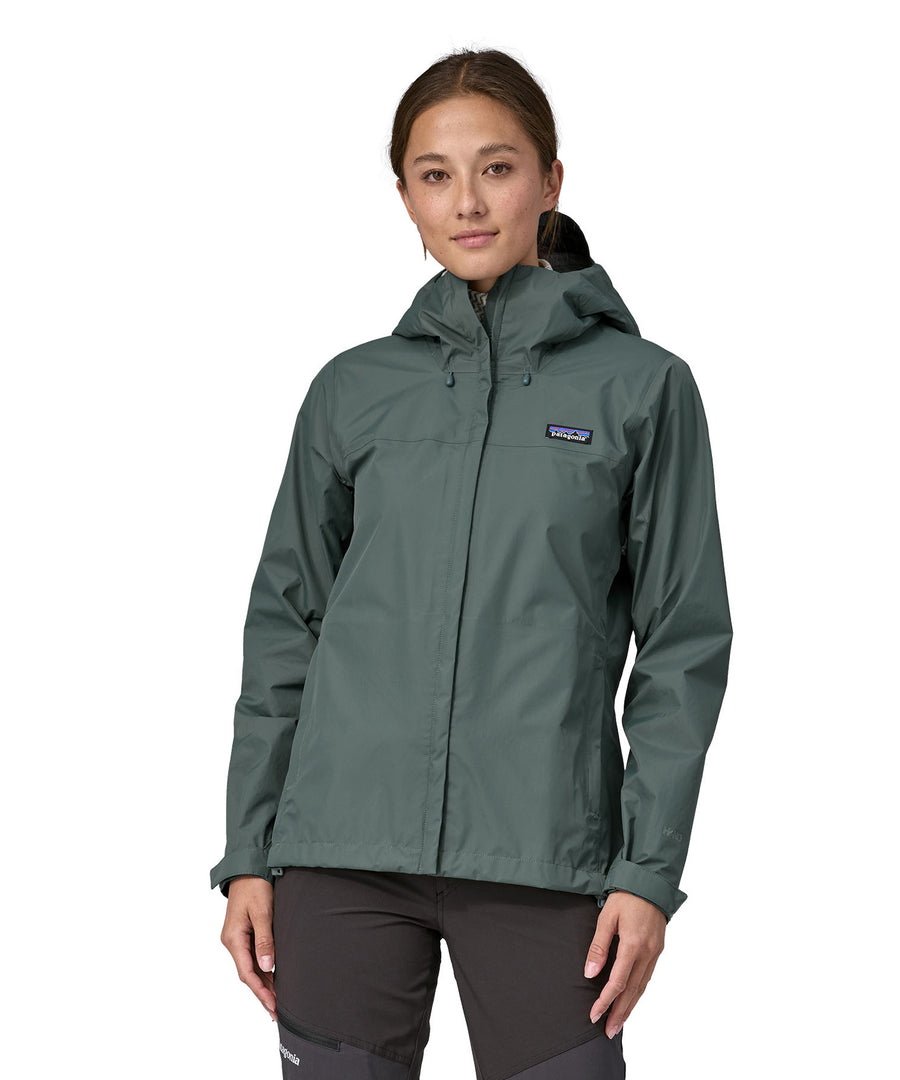 A woman wearing a Patagonia Women's Torrentshell 3L Rain jacket in a Nouveau Green showing the front.