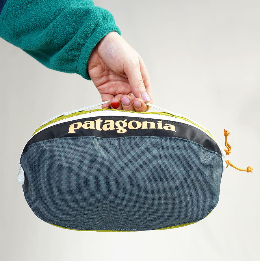 patagonia 3l travel cube wash bag held by a hand using the top hook to demonstrate that it can be hooked up