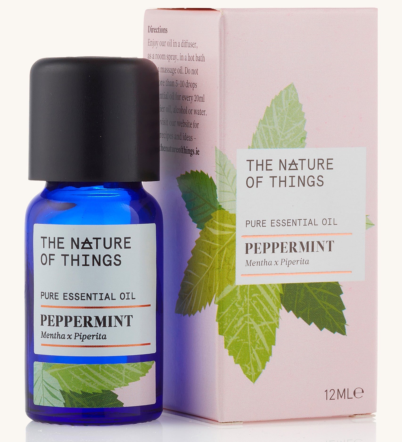 Organic Peppermint pure essential oil in a blue glass bottle in front of a decorative pink cardboard box.