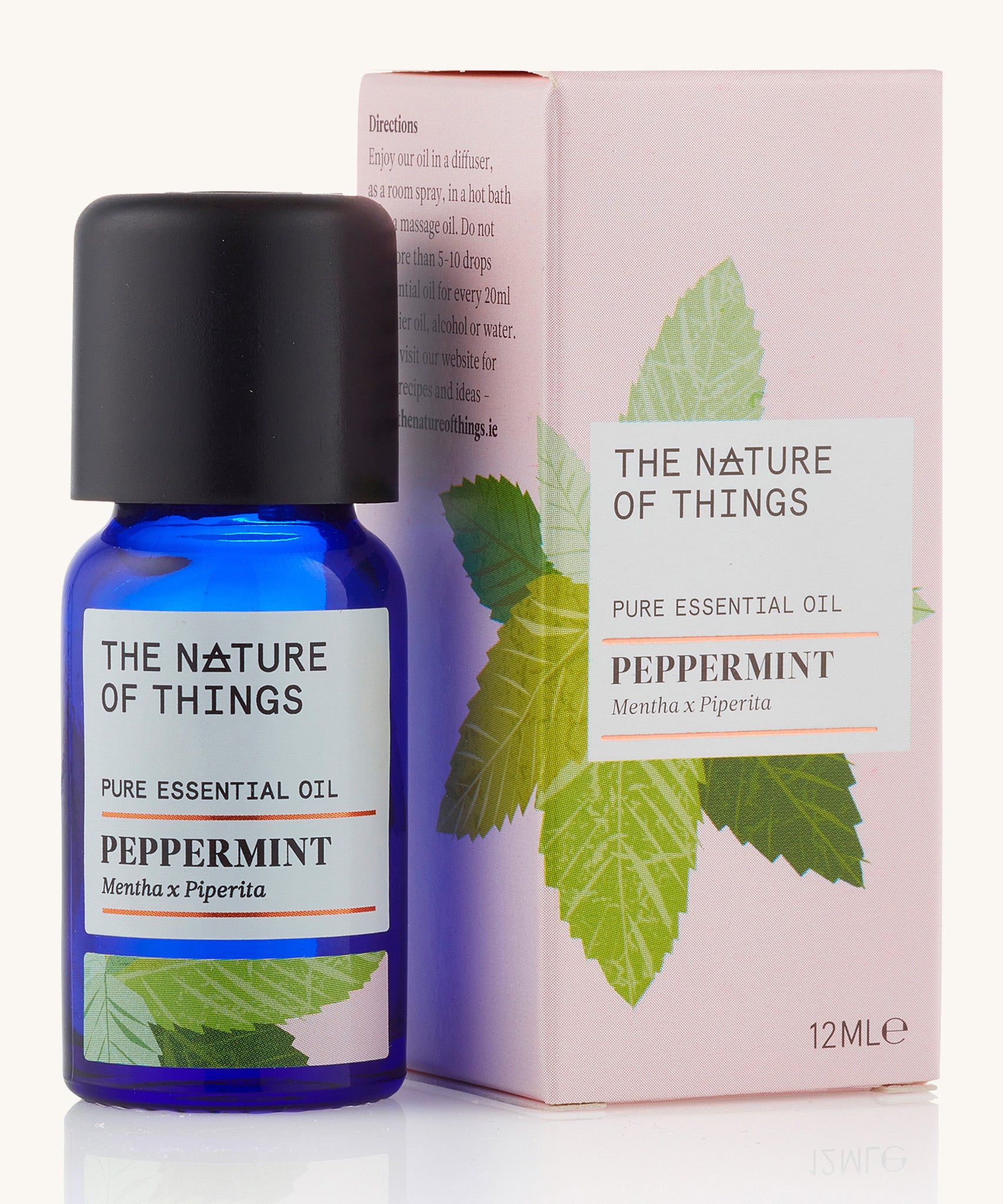 Organic Peppermint pure essential oil in a blue glass bottle in front of a decorative pink cardboard box.