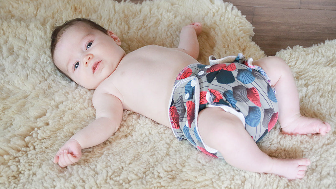 Baby on a fluffy rug, wearing a Petit Lulu bamboo reusable cloth nappy