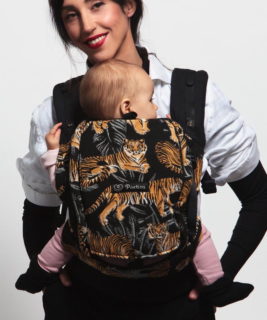 An adult carrying a baby in the Love Radius PhysioCarrier in Tiger.