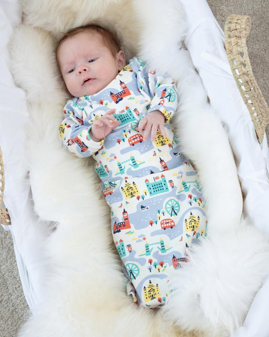 Baby laying on a fluffy white blanket wearing the eco-friendly Piccalilly little london nightgown