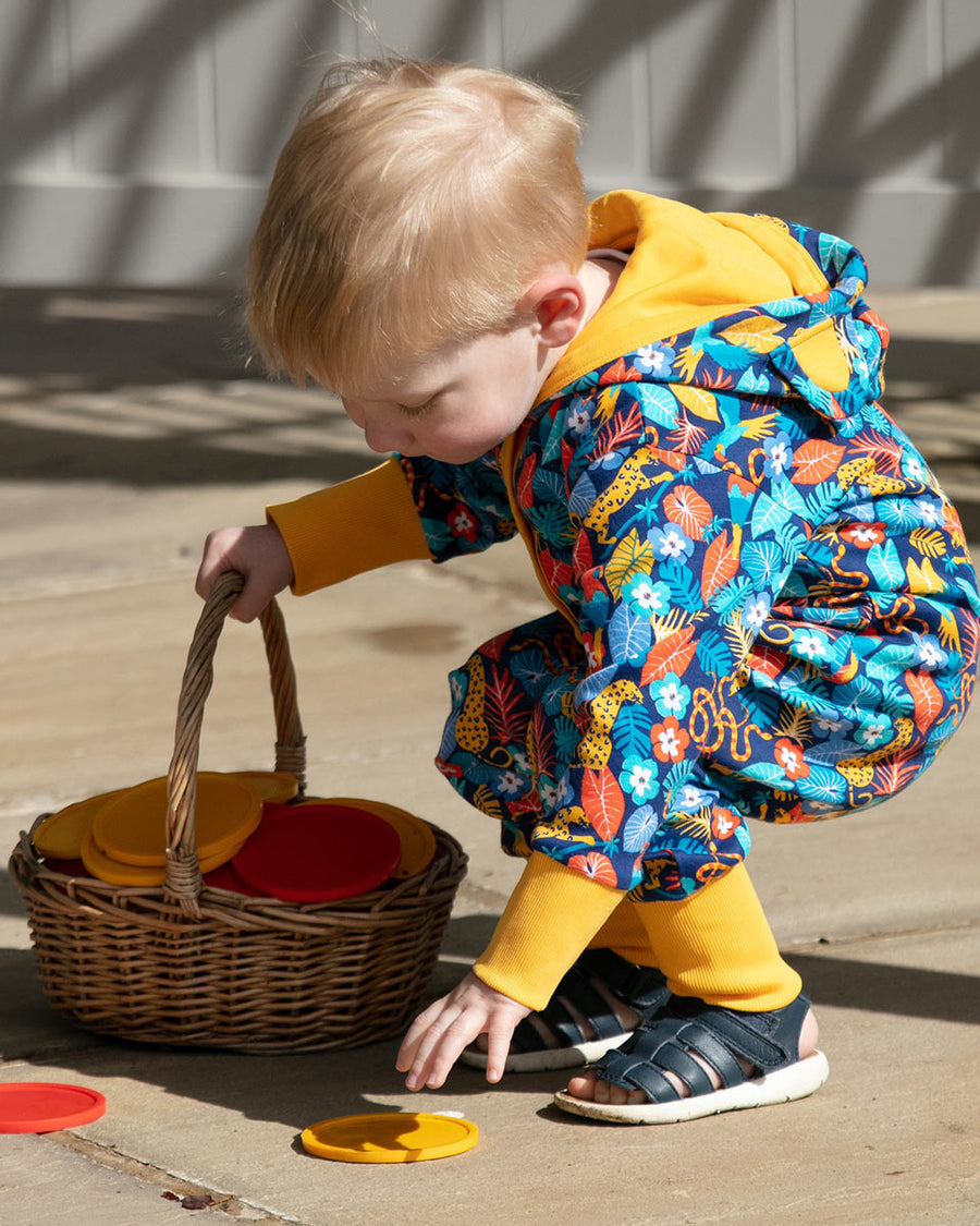 Close up of young child carrying a basket of toys