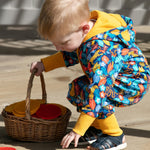 Close up of young child carrying a basket of toys