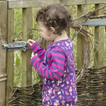 Close up of young girl wearing the Piccalilly organic cotton woodland dungarees