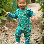 Young boy walking on some gravel wearing the Piccalilly kids organic cotton tree tops dungarees