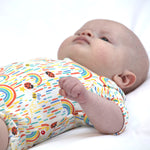 Close up of baby laying down wearing the Piccalilly rainbow print organic cotton body suit