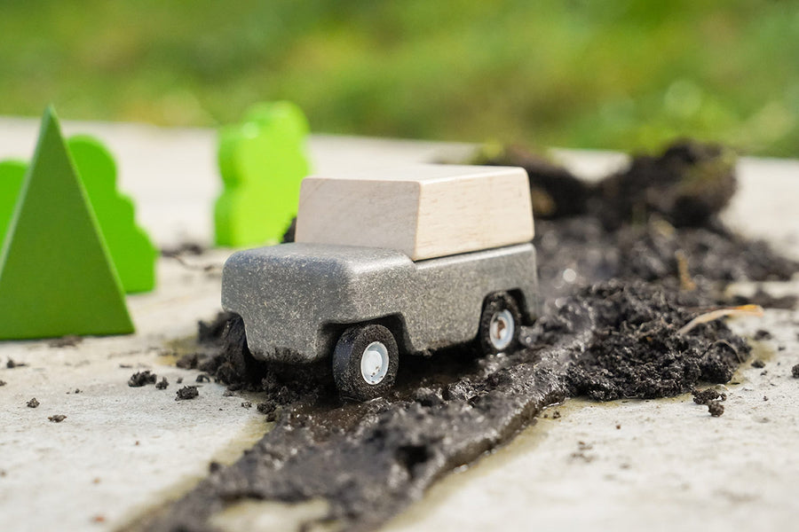 Close up of Plan Toys Wagon in a pile of mud