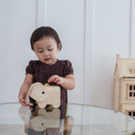 A child putting a coin in the PlanToys Elephant Money Bank.