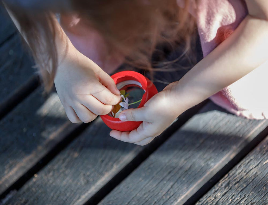 A close up of the detachable top from the PlanToys Kaleidoscope in a child's hands.