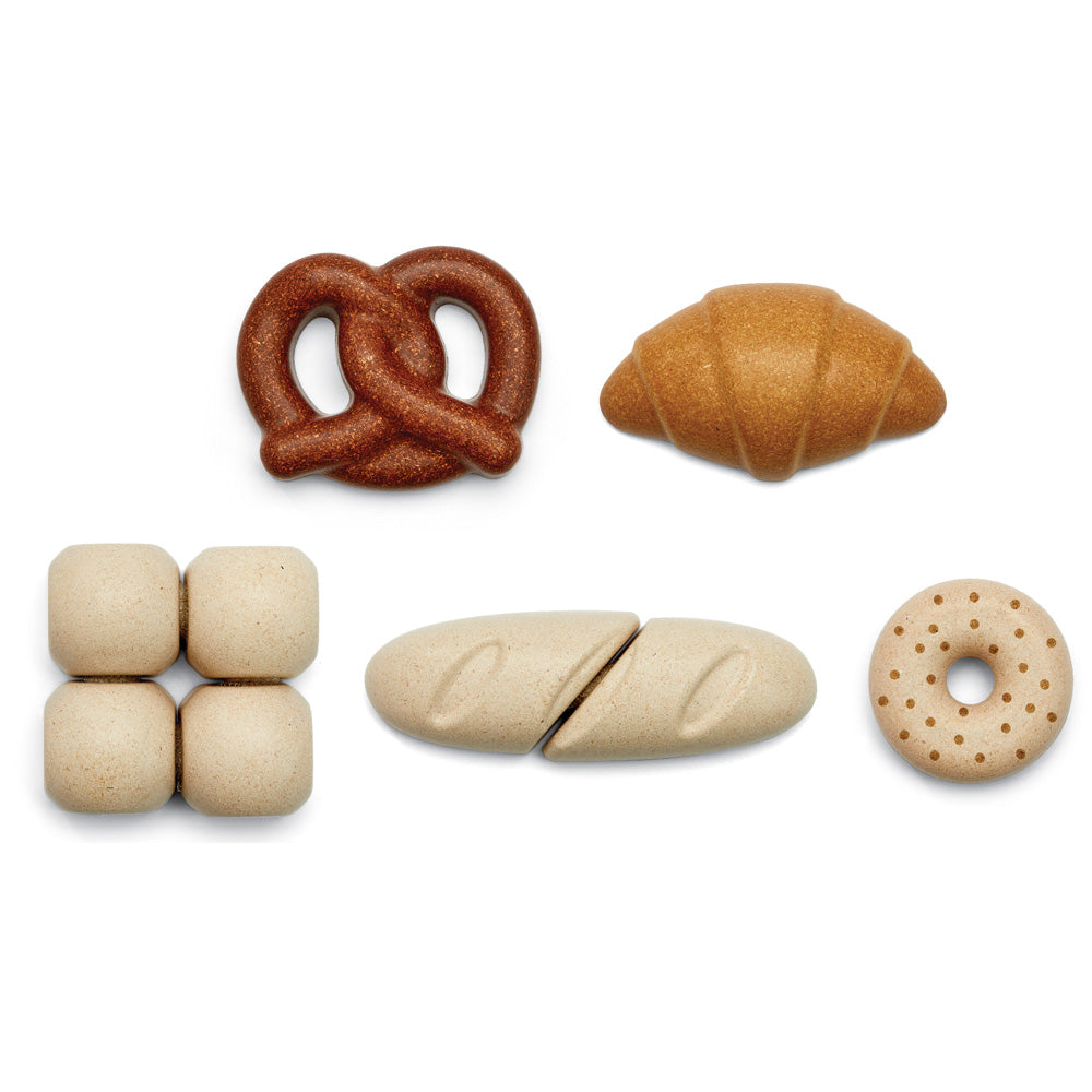 Plan Toys childrens wooden bread toy set laid out on a white background next to its soft fabric storage bag