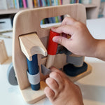 Close up of a hand pulling out a tool from the Plan Toys plastic free wooden carpenter role play toy set