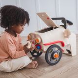 A child playing with the PlanToys Motor Mechanic role play toy.