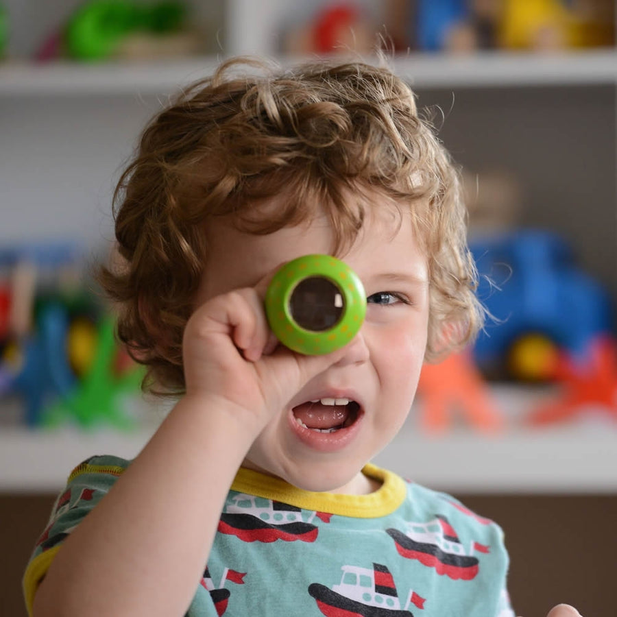 Child stacking three PlanToys Mushroom Kaleidoscopes