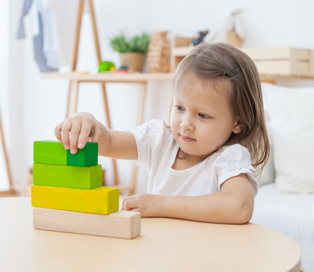 A child playing with the Plan Toys Ordering Blocks. 