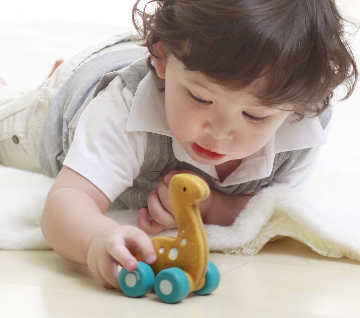 Child playing with the PlanToys Dino Car - Diplo