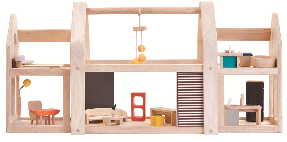 The PlanToys Slide N Go Dolls' House shown extended from the side with furniture inside on a plain background. 