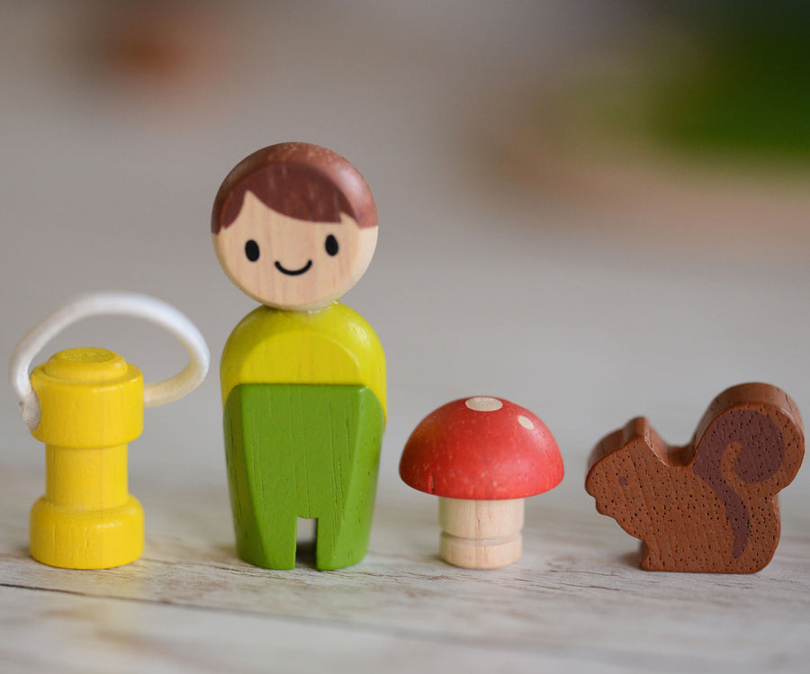 A line up of the lamp, doll, toadstool and squirrel pieces that come with the PlanToys PlanWorld tree house set. 