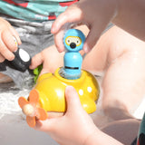 A close up of a child playing with the PlanToys Submarine Bath Toy placing the diver inside. 