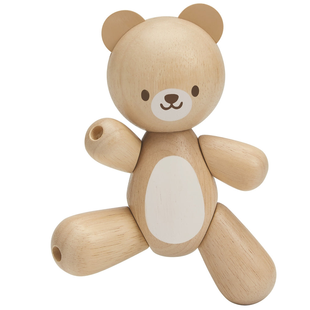 A PlanToys wooden toy bear on a plain background. 