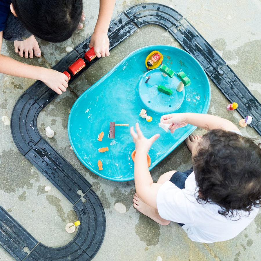 Child playing with the Plan Toys Water Play Set - an exciting play tray inspiring creative water play and is a fabulous sensory toy for toddlers. 