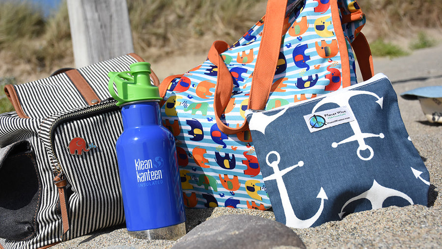 PlanetWise wetbag on the beach alongside a Klean Kanteen bottle and a Babipur playmat