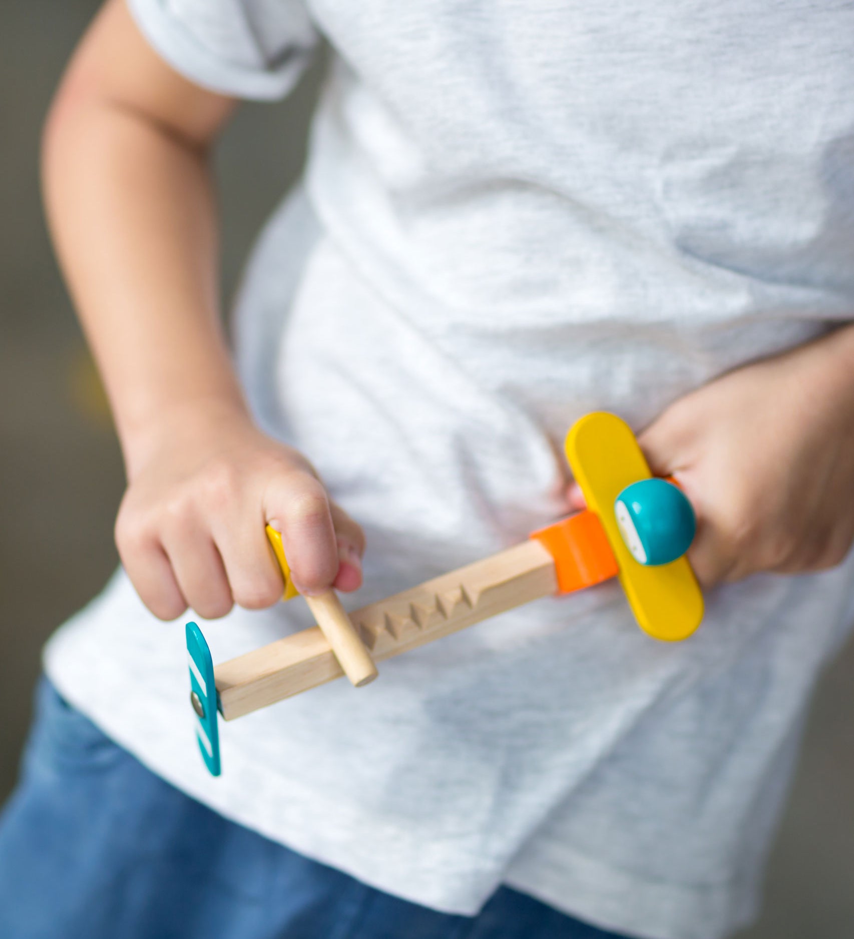  close up of a child playing with the PlanToys Spin N Fly Airplane.