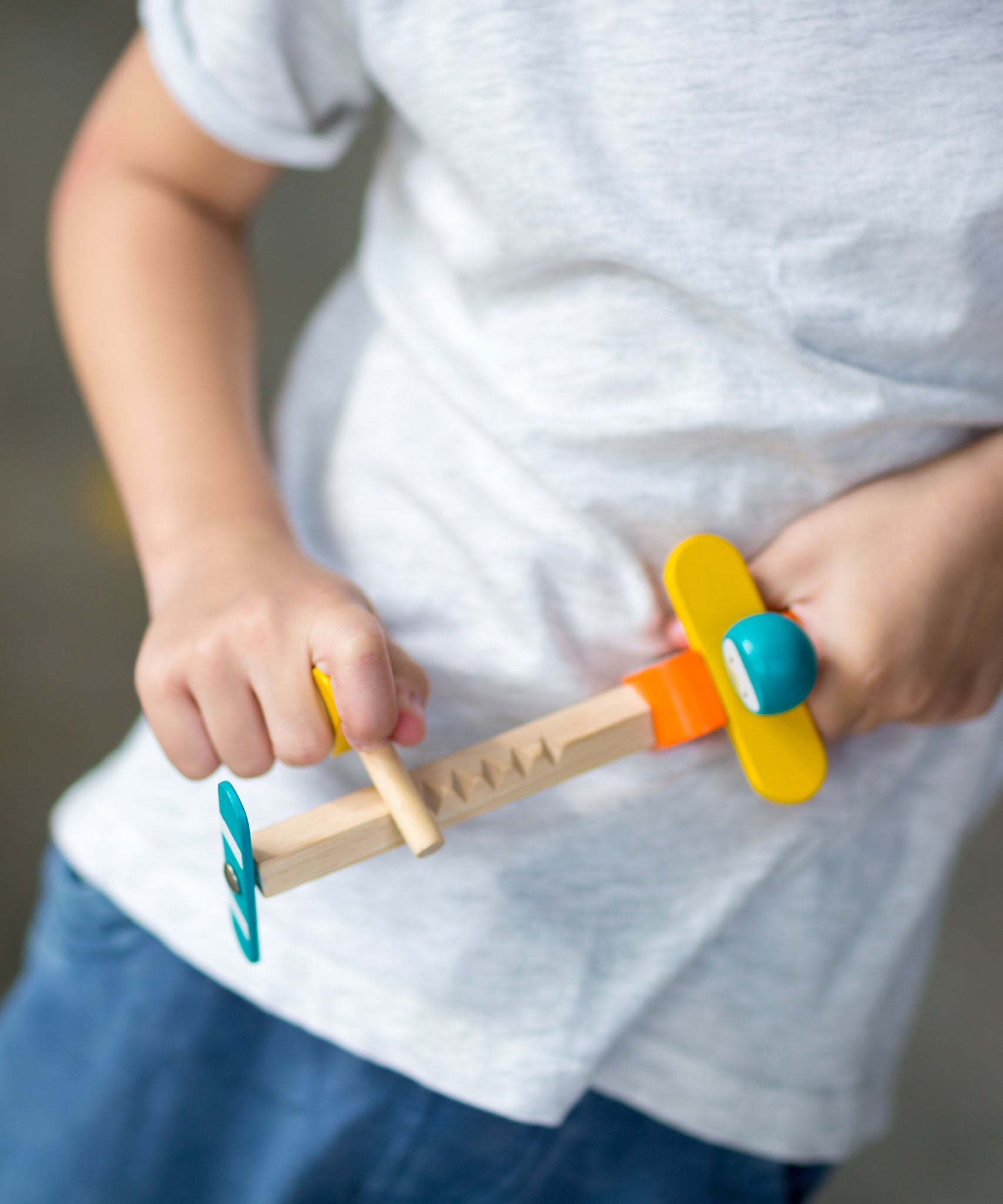  close up of a child playing with the PlanToys Spin N Fly Airplane.