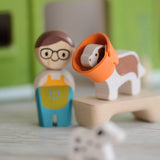 A closeup of the PlanToys wooden dog from the pet shop, with a rubber cone around its neck.