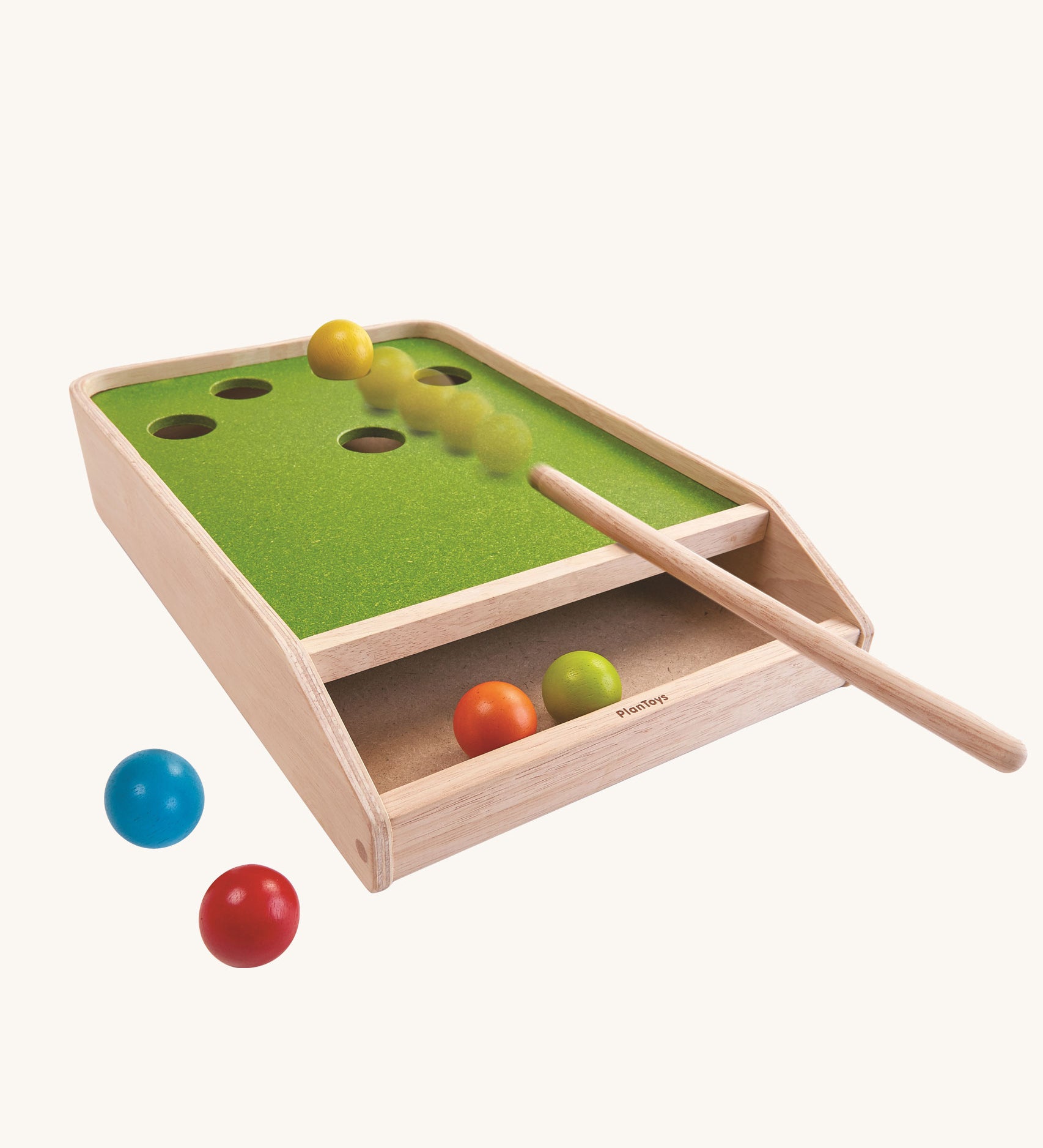 The PlanToys Ball Shoot Board Game on a plain background. Motion can be seen as the cue hits the yellow coloured ball. 