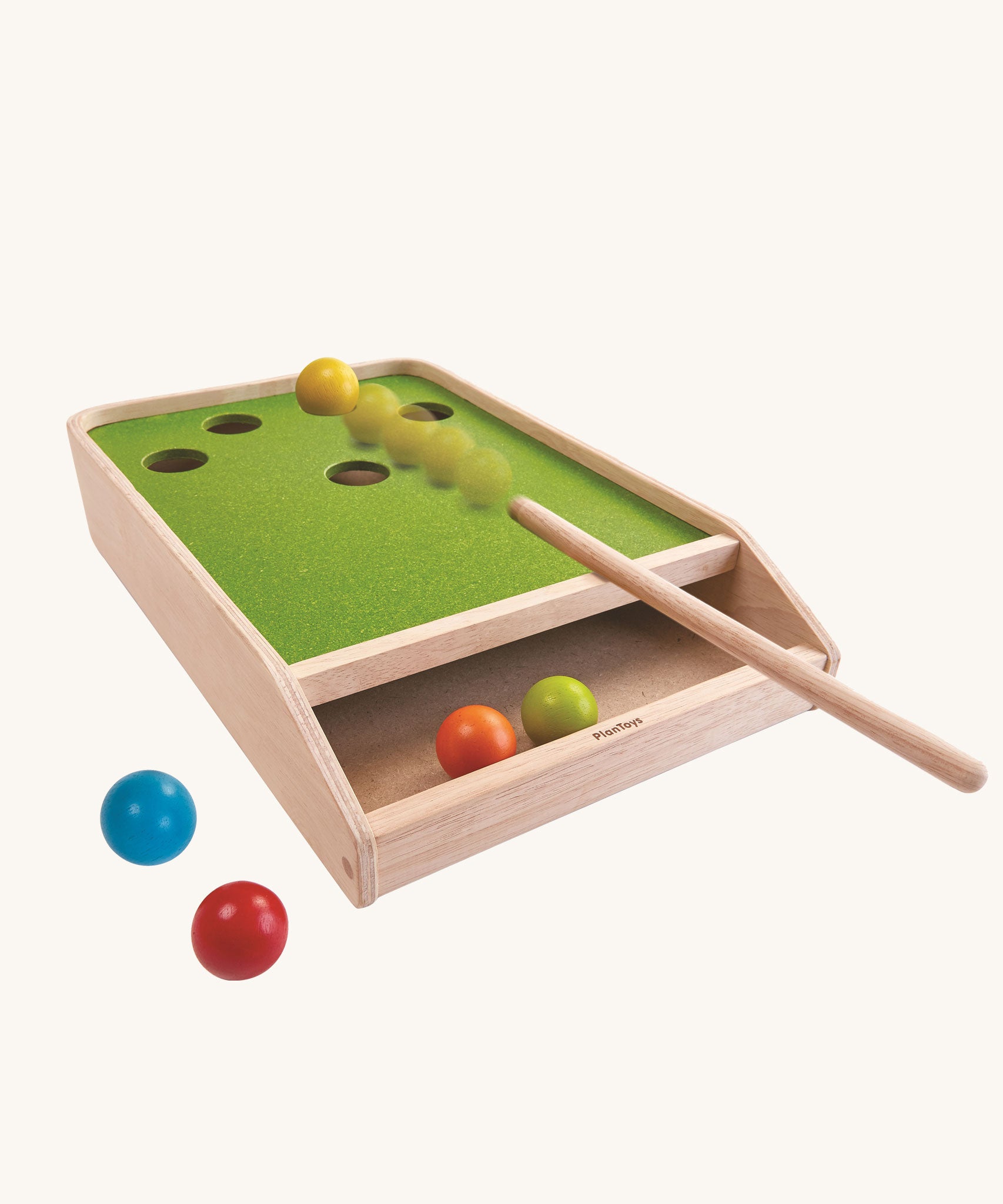 The PlanToys Ball Shoot Board Game on a plain background. Motion can be seen as the cue hits the yellow coloured ball. 